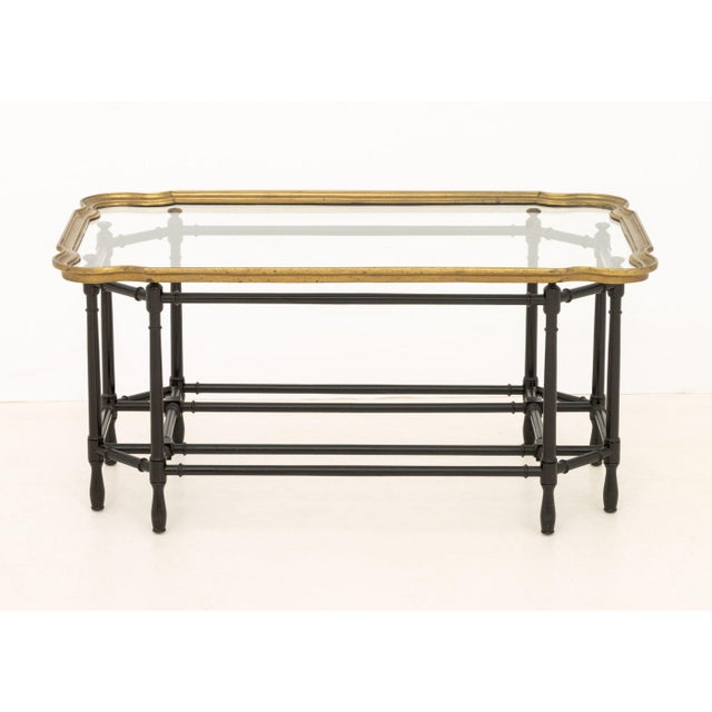 Hollywood Regency Faux Bamboo Coffee Table, the glass top with brass gallery and above an ebonized wood base. 18.25" H x...