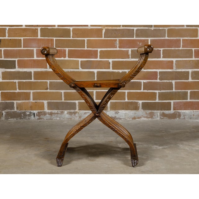 An Italian Renaissance style walnut Savonarola folding chair from circa 1900 with lion paw feet. This Italian Renaissance...