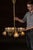 A bright brass chandelier with six elegantly curved arms, each fitted with a deeply ribbed etched glass shade. The design...