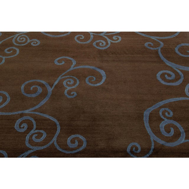 This contemporary Tibetan rug is expertly crafted by hand using wool and silk and boasts a striking brown color field....