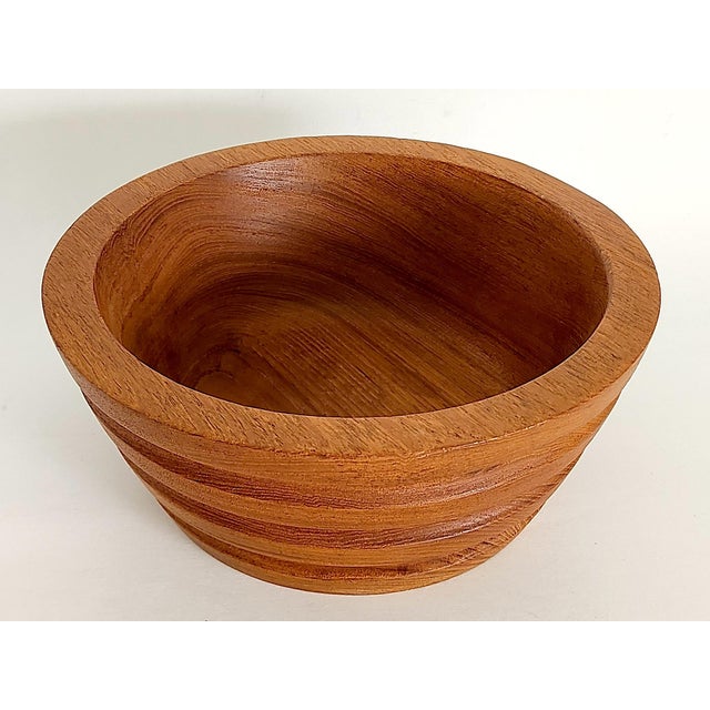 Offered is a sturdy staved and lathed Teak wood turned bowl. It features hand-carved grooved ribbed sides, an almost 1"...