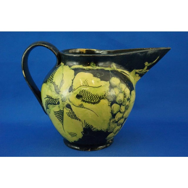 A fabulous glazed and vitrified ceramic jug, entirely hand-crafted on a lathe and decorated with bunches of grapes and...