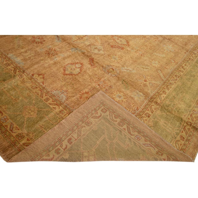 Beautiful Vintage Turkish Oushak hand-knotted wool rug with a brown color field. This rug has green and rust accents in a...