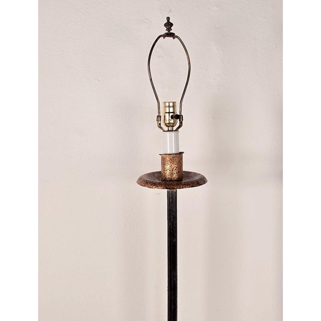 A pair of wrought iron torchères with gilt accents, circa 1970. Height measures 66.5" finial, 57.5" harp.