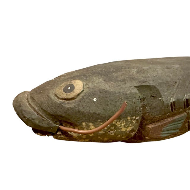 A completely charming, hand carved fishing decoy. Features a hand carved and painted decoy I. The firm of a catfish or...