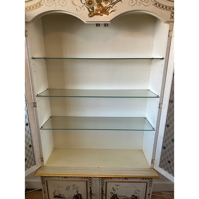 An exceptional and highly decorative bonnet-top display cabinet by John Widdicomb, showcasing the sophisticated...