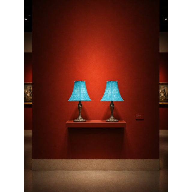 Matching pair of decorative table lamps featuring vibrant turquoise textured fabric shades and dark bronze-tone sculptural...