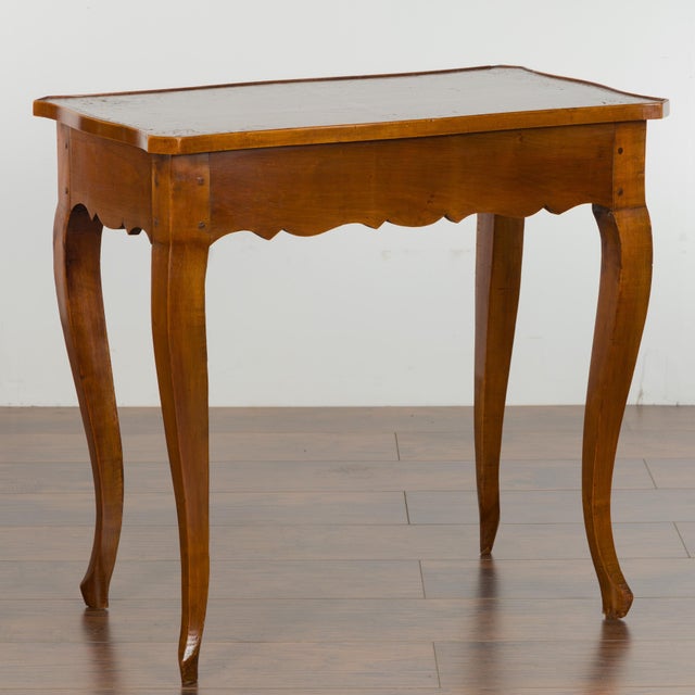 A French walnut side table from the 19th century, with leather top, long lateral drawer and cabriole legs. Created in...