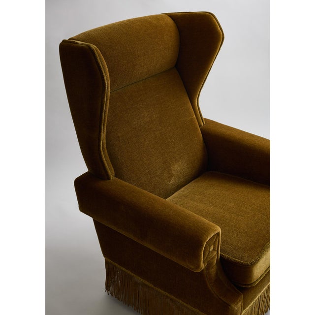 Vintage Scandinavian wingback lounge chair, circa 1950s, upholstered in warm olive-gold mohair. A tall, gently contoured...