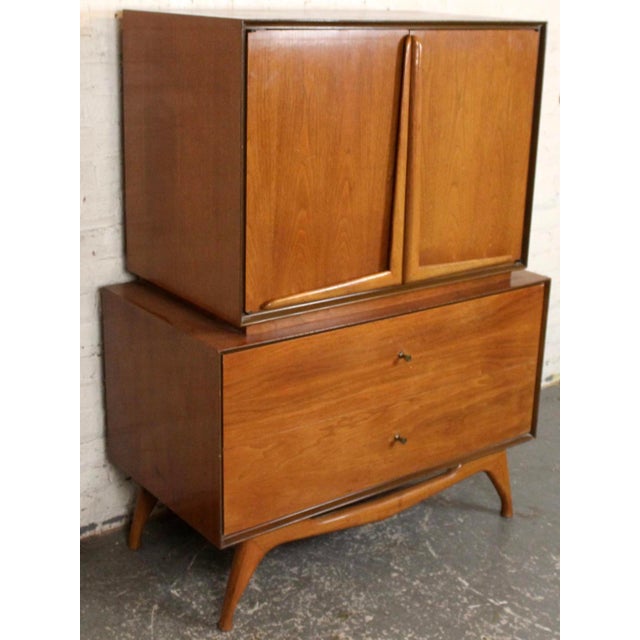 Mid-Century Modern sculptural walnut highboy dresser featuring elegant splayed legs and distinctive boomerang-shaped...