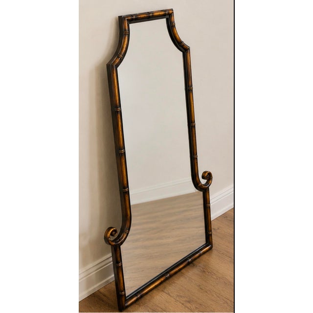 A striking Uttermost faux bamboo pagoda wall mirror featuring an elegant architectural silhouette with classic Chinoiserie...