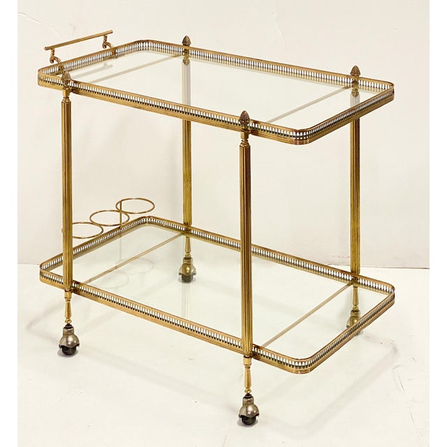 A fine vintage French bar trolley or drinks cart (also known as a serving or tea trolley) of brass with glass shelves, in...