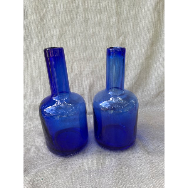 Heavy vintage handblown cobalt blue glass bottles. A pair that are very similar in shape to one another, but not exact....
