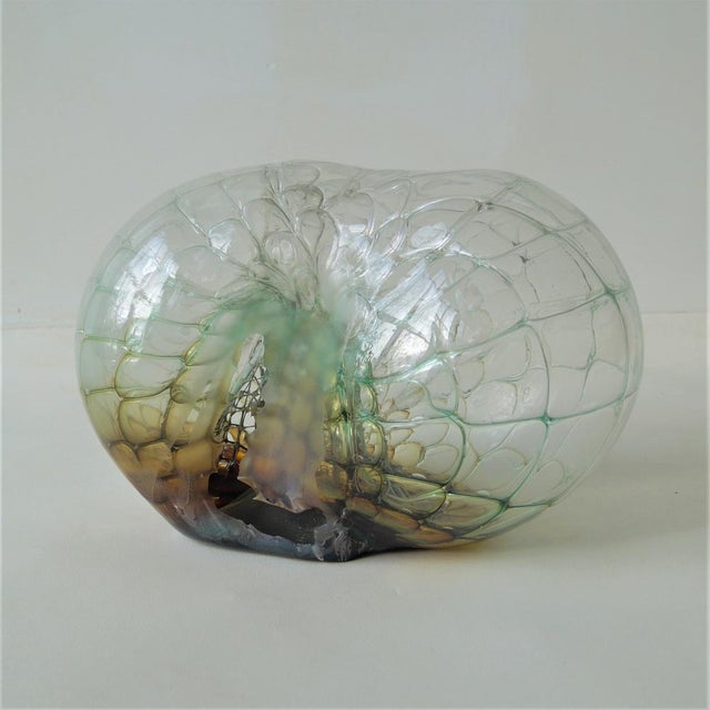 A impressively large clear glass sculpture with a green/yellow/cognac glass core, clear glass overlay and metal mesh...
