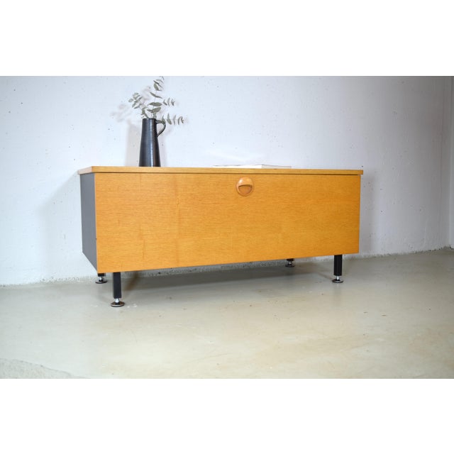 This is a compact sideboard from the 1960s, manufactured by VEB Deutsche Werkstätten Hellerau. The cabinet features a...