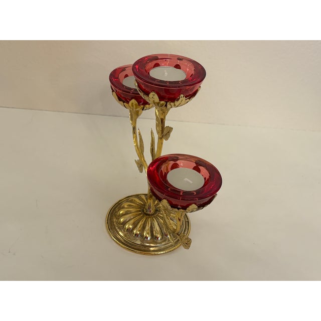 This Hollywood regency candleabra holds 3 small red cups for tea lights. It is am impressive piece as it stands out in...
