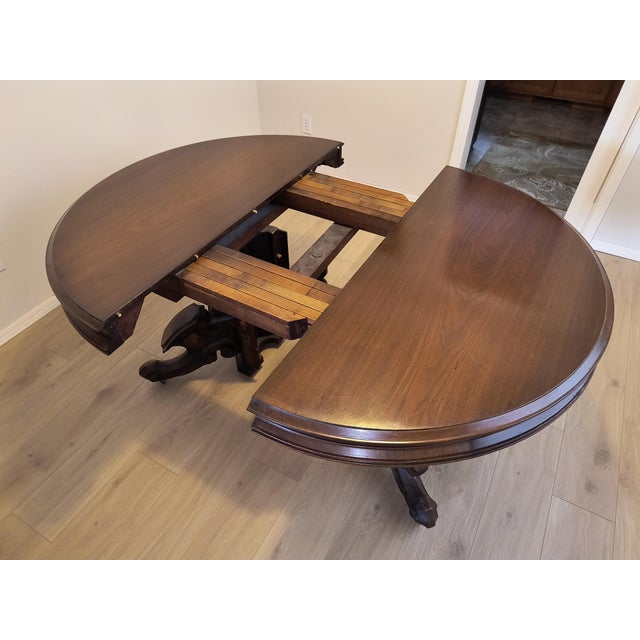 Solid Walnut Dining Table ca 1870. Round top with sculpted pedestal base. Base has wheels to ease moving and extending....