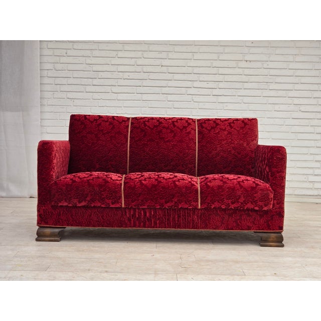 1950s, Danish 3-seater sofa. Red furniture velour, oak wood legs, brass springs in the seat. Sofa was reupholstered by...