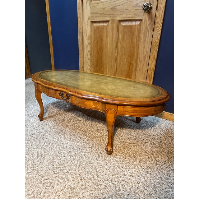 Elegant mid-20th century American French Provincial (Louis XV style) oval coffee table. Features graceful cabriole legs...