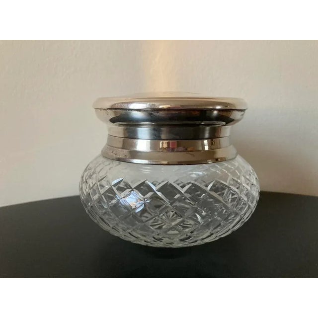 A beautiful art glass jar with silver lid, circa mid 20th century, England, Europe. The glass container has diamond ornate...