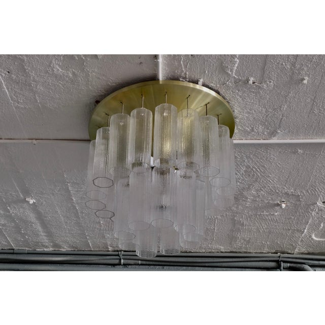 This flush mount or chandelier is made of glass with a brass base and remains in good vintage condition. Signed by...