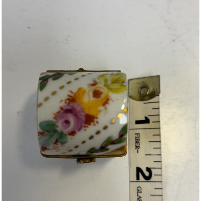 Adorable hand-painted porcelain footed chest from Limoges, decorated in gold on both sides with flower motif. The lock is...