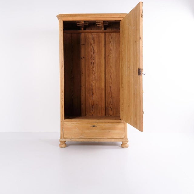 Chamber cabinet from the early 1900s, crafted in pine wood with a simple, classic design. The cabinet stands on round legs...