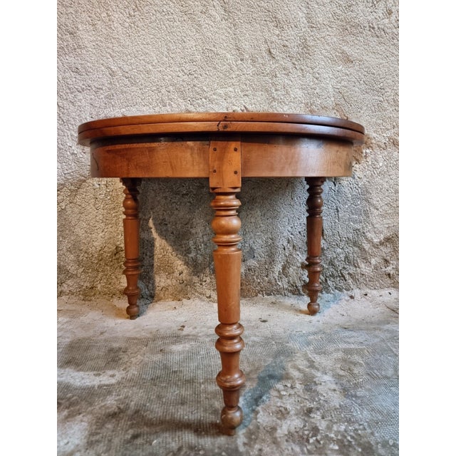 This antique French demi-lune table dates from the early 20th century and is crafted from solid walnut. Designed with a...