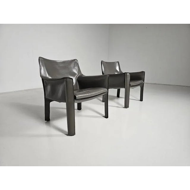 Set of 2 Cassina “Cab” 414 armchairs in elephant grey saddle leather. Designed by Mario Bellini and manufactured by...
