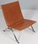 Poul Kjærholm lounge chair in patinated tan leather. Frame of brushed steel. Model PK22, made by Fritz Hansen. This piece...