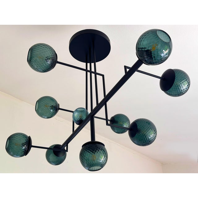 Scenographic chandelier with green-petrolio spheres in Murano glass . The spheres are working in "ballotton" a traditional...