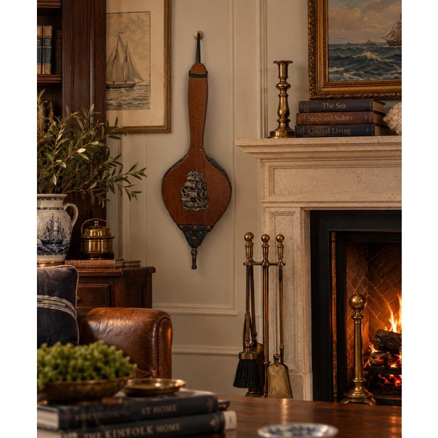 Charming vintage fireplace bellows featuring a warm wood body accented with dark metal details and a dimensional sailing...