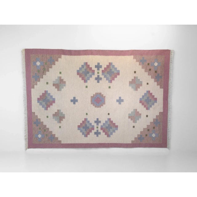 Very large mid-century Swedish kilim in tones of pink and a cream base, geometric design with hints of blues and green....