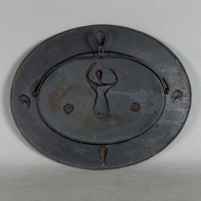 A striking and dramatic cast iron oval wall medallion with bas-relief detail, a refined expression of the European Neo-...