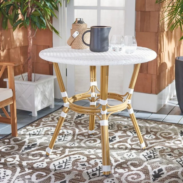 Embrace your inner Parisian with this traditional rattan bistro side table. Crafted to honor the classic French design,...