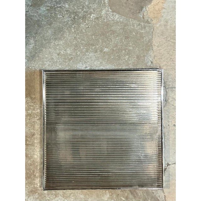 This vintage geometric wall panel presents a clean square silhouette dominated by a striking ribbed mirror surface, its...