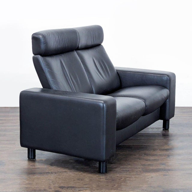 This Stressless loveseat offers a sleek and modern look with black leather upholstery. It comfortably seats two and...