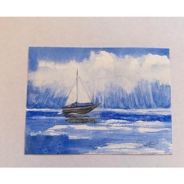 A sailboat making its way across the ocean with the rain in the background, signed and ready to frame. Nancy Smith studied...
