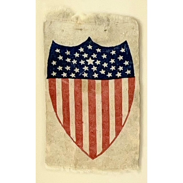Silk flag ribbon that has 38 stars dating it to 1876. In the shape of a Federal Shield with is semi rare to find. This...