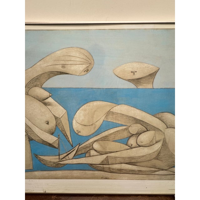 The image shows a framed art print of Pablo Picasso's 1937 work La Baignade (On the Beach). ® • Artist: Pablo Picasso •...