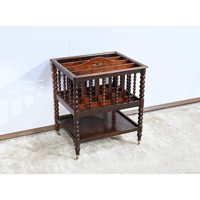 This magazine rack has in the upper part four identical compartments with bars ordered from a handle. The frame is...