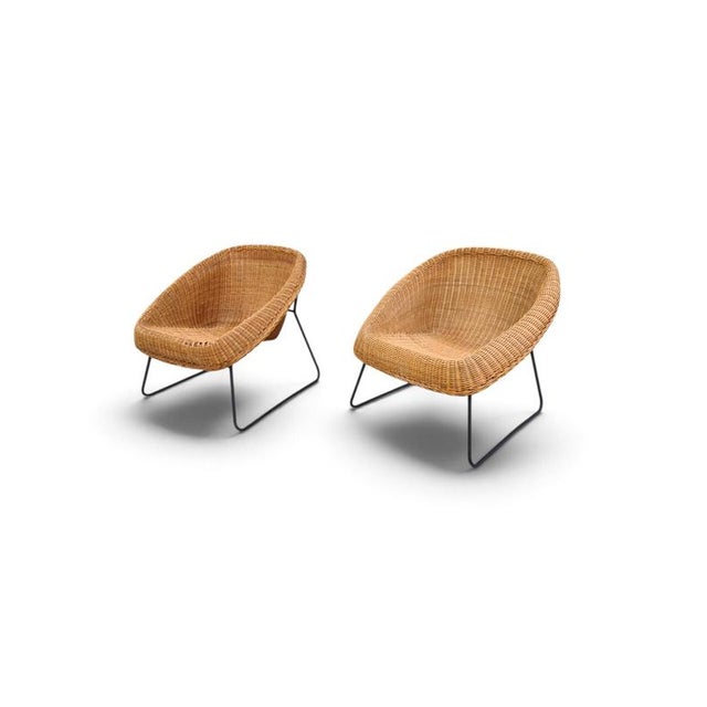 Specifications This pair of 1960s French armchairs features a classic mid-century silhouette defined by natural materials....
