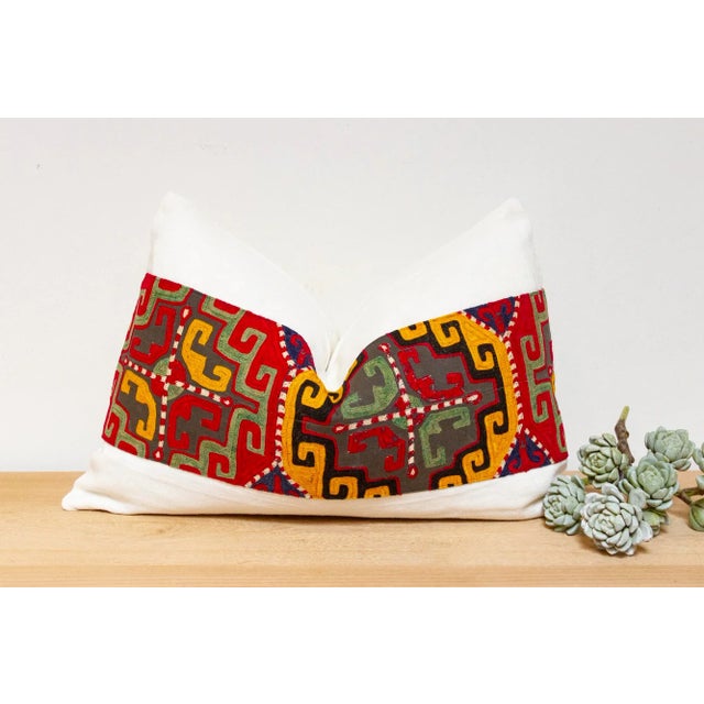 This handcrafted pillow features a vibrant, hand-stitched textile created by the Lakai tribe of Uzbekistan. It is a unique...