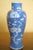 A decorative Chinese blue-and-white porcelain vase featuring white prunus blossoms against a soft blue cracked-ice ground....