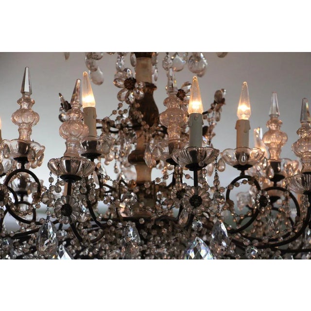 A most charming italian 19th century pressed patinated metal, giltwood and crystal twelve lights genovese chandelier. This...