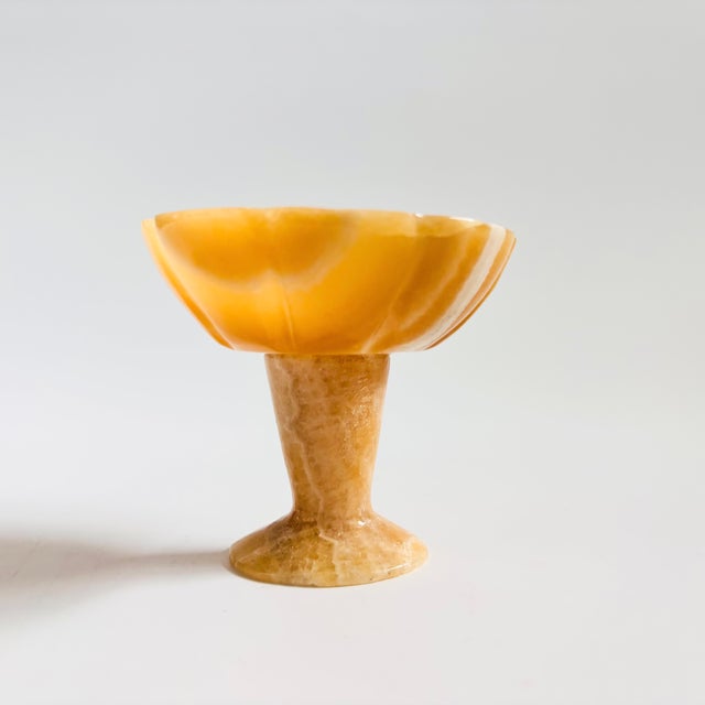 A small vintage alabaster bowl with a pedestal base. Lovely natural yellow-tan color to the stone and natural veining....