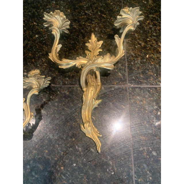 Stunning pair of highly sought after, large wall sconces with Rococo vibes. These two-armed, heavy brass candle sconces...