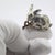 Vintage miniature sculpture with a sweet, naturalistic charm, depicting a little rabbit holding a twig, handcrafted in...