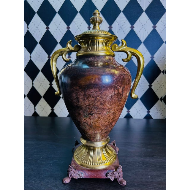 A pair of large metal decorative urns combining classical form with an unusually rich, mottled brown finish and...