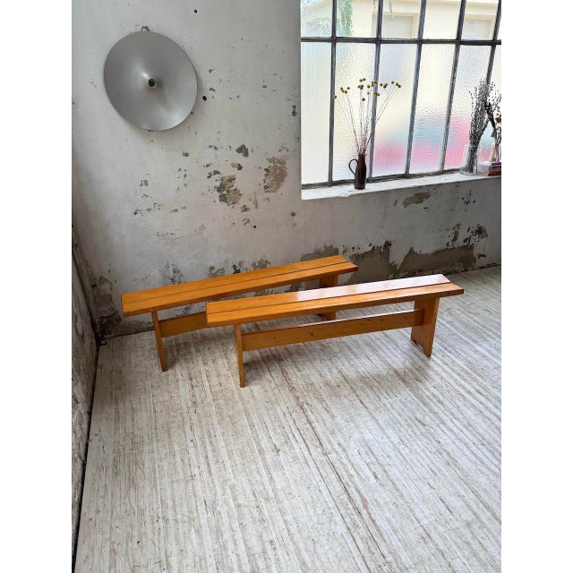 Set of two pine benches for Les Arcs, 1970, selected by Charlotte Perriand. They feature a seat made of two slats sloping...